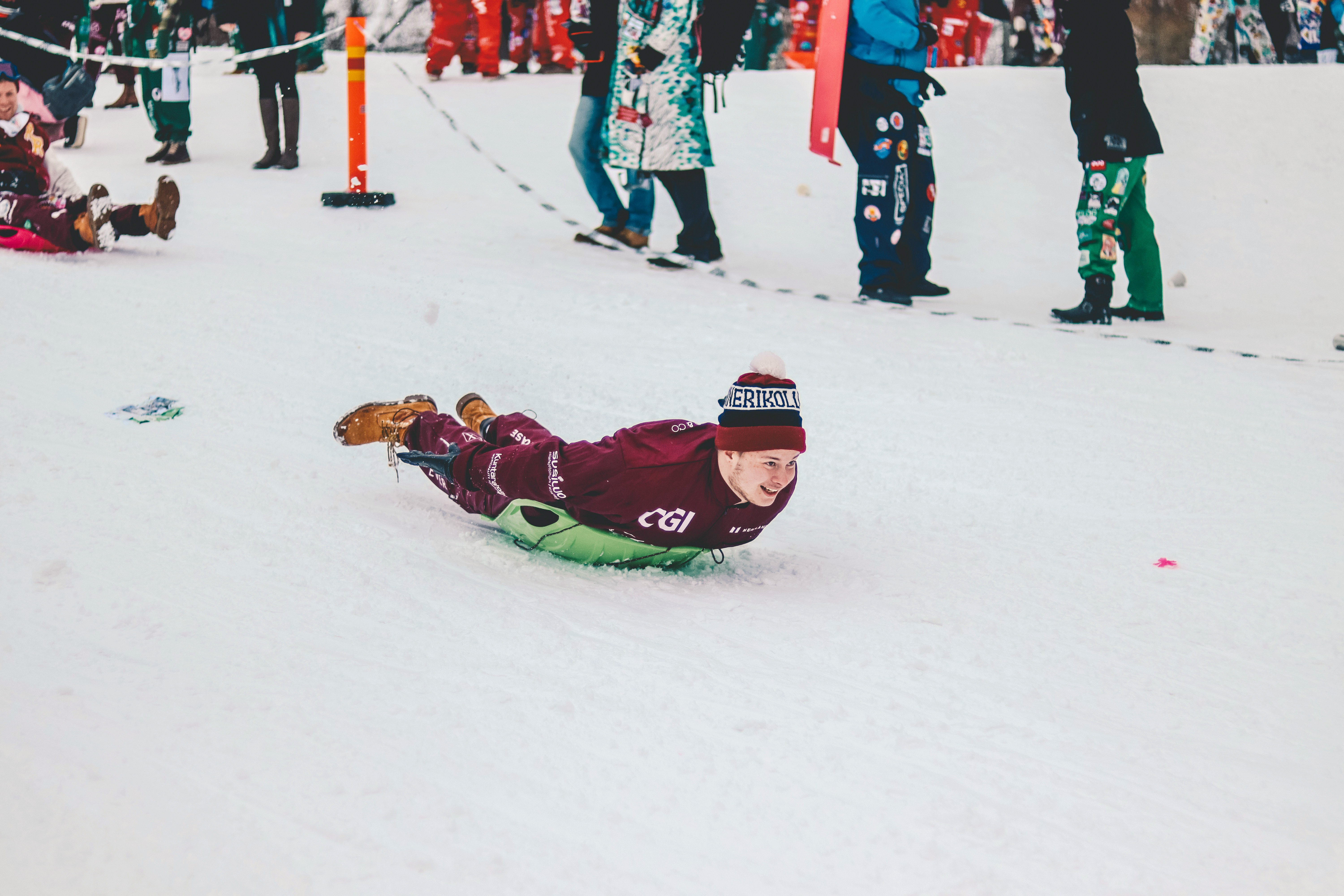 Corporate event team participating in a night-time torchlit yooner sledge descent down an Alpine mountain