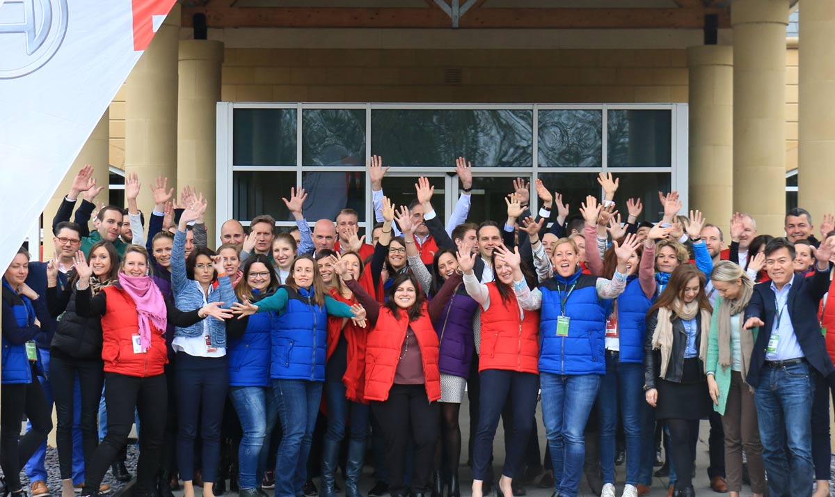delegates in group photo with hands up wearing colourful gilets